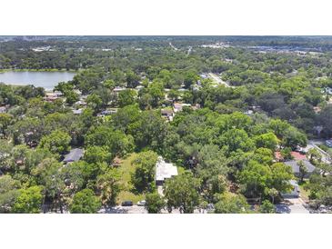 An aerial view of a property surrounded by mature trees and landscaping near a lake and adjacent neighborhood at 626 Cannon St, Daytona Beach, FL 32114