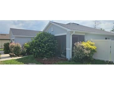 Home's exterior showcases lush landscaping and screened porch for outdoor enjoyment at 3339 Croton Ave, Deltona, FL 32738