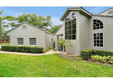 Charming home featuring a landscaped yard and stucco exterior, with an arched window and lovely curb appeal at 3988 Radley Ct, Longwood, FL 32779