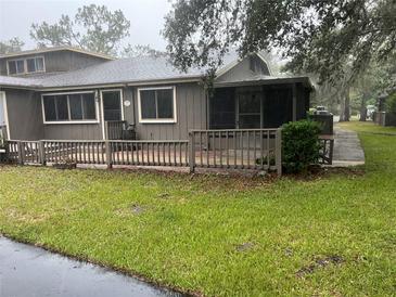 Inviting townhouse featuring a covered porch and a well-maintained, green lawn at 79 Cypress Pond Rd # 79, Port Orange, FL 32128