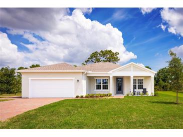 Single-story home with a white garage door and a manicured lawn at 2105 Aibonito Cir, Clermont, FL 34711