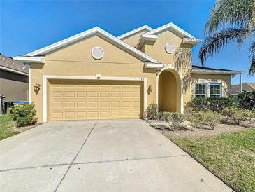 Charming single-Gathering home featuring a two-car garage, manicured lawn, and bright stucco exterior at 2588 Egret Loop, Kissimmee, FL 34743