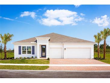 White two-story house with three-car garage and palm trees at 1912 Quail Fields Cir, Winter Haven, FL 33884