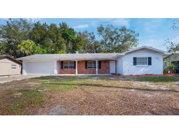 Charming single-story home with brick accents, a well-maintained lawn, and a two-car garage at 1360 10Th Ne Ct, Winter Haven, FL 33881