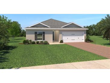 Charming single-story home with a well-manicured lawn, two-car garage, and brick driveway at 1534 Landon Ln, Haines City, FL 33844