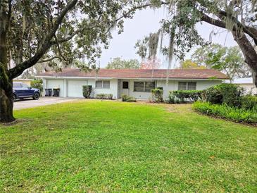 Charming single-story home with a well-maintained lawn and mature trees at 3621 Conine E Dr, Winter Haven, FL 33881