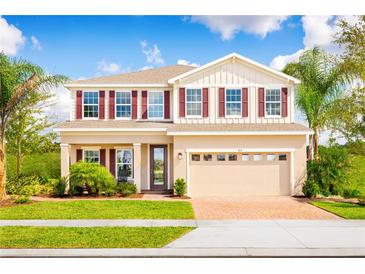 Two-story house with beige walls, red shutters, and a brick driveway at 7405 Sw 108Th St, Ocala, FL 34476