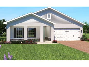 Inviting single-Gathering home with manicured lawn, charming shutters, and attached two-car garage at 1412 Laramie Way, Haines City, FL 33844