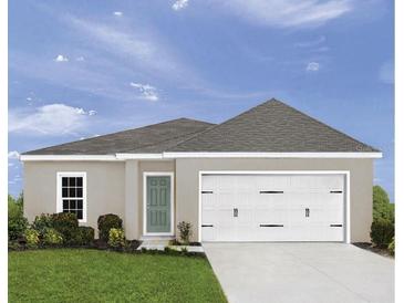 Charming single Gathering home showcasing a well-manicured lawn and a two car garage at 2183 Oklahoma Dr, Sumterville, FL 33585