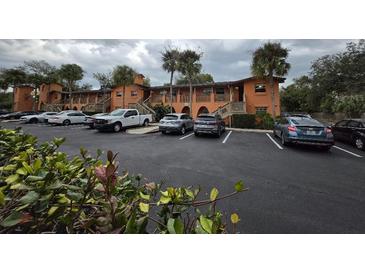 Condominium building with a parking lot in front at 722 E Michigan St # 145, Orlando, FL 32806