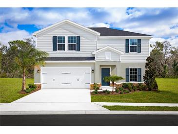Charming two-story home with a well-manicured lawn, a two-car garage, and stylish architectural details at 4208 Cattail Marsh Dr, Lakeland, FL 33811