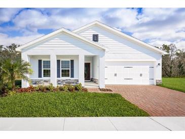 Charming single-story home showcasing a well-manicured lawn and a brick-paved driveway, offering a blend of comfort and curb appeal at 4220 Cattail Marsh Dr, Lakeland, FL 33811
