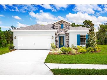 Charming single-Gathering home with a two-car garage, stone accents, lush landscaping, and blue shutters at 4226 Cattail Marsh Dr, Lakeland, FL 33811