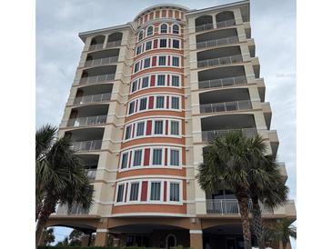 Beautiful multi-story building with balconies, decorative insets, and palm trees at 1425 Ocean Shore Blvd # 402, Ormond Beach, FL 32176