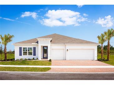 Beautiful single-story home with a brick driveway, blue shutters, and lush landscaping at 1916 Quail Fields Cir, Winter Haven, FL 33884