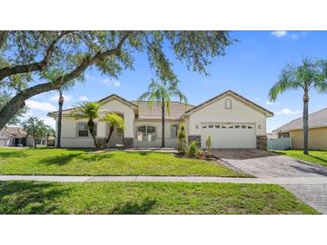 Inviting single-story home with a well-manicured lawn, a tile roof, and a two-car garage at 3601 Weatherfield Dr, Kissimmee, FL 34746