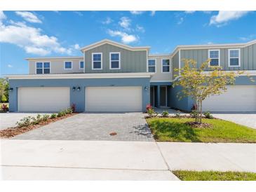 Charming townhome featuring a two-car garage, blue exterior, and well-manicured landscaping at 5244 Luisa Ct, St Cloud, FL 34771