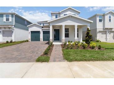 Charming two-story home featuring a two-car garage and inviting front porch with manicured landscaping at 9432 Emerald Berry Dr, Winter Garden, FL 34787
