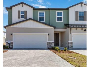 New two-story townhome showcasing modern architecture, attached garage and inviting front yard in a Primary-planned community at 2473 Magnolia Reserve Rd, Ocoee, FL 34761