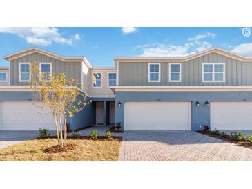 Charming townhome featuring a two-car garage, a light blue painted exterior, and manicured landscaping at 5289 Luisa Ct, St Cloud, FL 34771