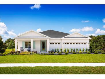 Charming one-story home with a well-manicured lawn, white trim, and a two-car garage at 11026 Nellie Crossing Cir, Clermont, FL 34711
