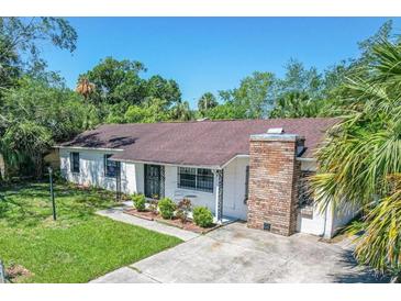 Charming single-story home featuring a brick chimney, mature landscaping, and a well-maintained lawn at 202 Yale Dr, Sanford, FL 32771
