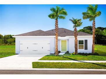 Charming single-story home showcasing a two-car garage, lovely landscaping, and a bright yellow-green front door at 1573 Texas Ave, Sumterville, FL 33585
