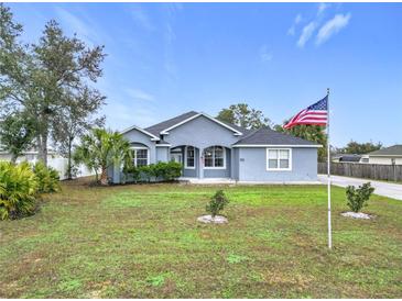 Charming single-story home features a well-manicured lawn and an American flag at 4649 Sw 103Rd Street Rd, Ocala, FL 34476