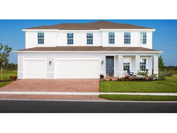 Two-story home with brick driveway, three-car garage, covered porch, and manicured lawn at 9836 Pine Mill Ct, Clermont, FL 34711