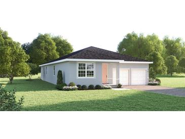 Charming single-story home featuring a well-manicured lawn, a two-car garage, and lovely landscaping at 114 Venetian Palms Blvd, New Smyrna Beach, FL 32168