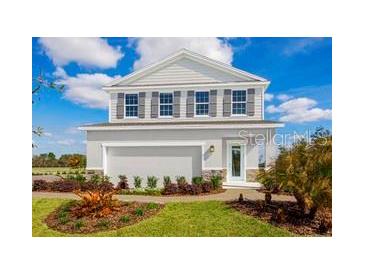 Charming two-story home featuring a clean gray exterior, complemented by dark shutters and a well-manicured front yard at 1310 Whispering Ln, Minneola, FL 34715