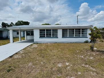 Charming single-story home featuring a metal roof, carport, and multiple windows at 232 Thomas Ave, Frostproof, FL 33843
