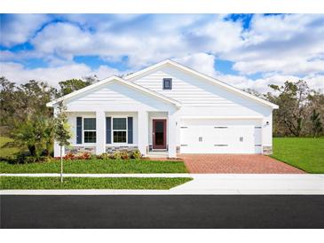 Beautiful single-Gathering home featuring a brick driveway, two car garage, and a well-manicured front lawn at 1381 Laramie Way, Haines City, FL 33844
