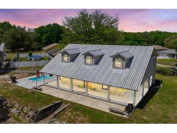 Charming home featuring a metal roof, inviting front porch, and a refreshing swimming pool on a spacious lot at 13700 Sw 108Th Ln, Dunnellon, FL 34432