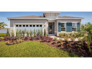 Charming single-story home with manicured lawn, colorful landscaping, and attached two car garage at 1556 Covey Rise Ter, Winter Haven, FL 33884