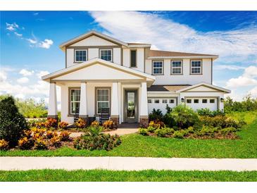 Stunning two-story home with a manicured lawn and a welcoming front porch, perfect for relaxing and enjoying the outdoors at 3186 Tiger Palm Way, New Smyrna Beach, FL 32168