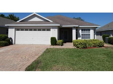 Charming one-story home with well-maintained landscaping, a brick driveway, and a two-car garage at 3806 Osprey Pointe Cir, Winter Haven, FL 33884