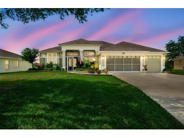 Beautifully landscaped home with well-manicured lawn and three-car garage, creating inviting curb appeal at 27223 Nostalgia Dr, Leesburg, FL 34748