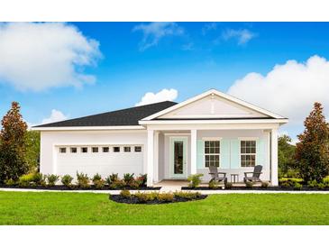 Charming single-story home featuring a two-car garage, covered porch, and well-manicured landscaping at 1278 Whispering Ln, Minneola, FL 34715