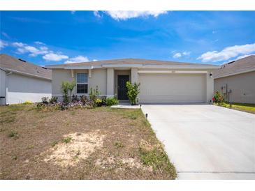 Charming single-story home with a two-car garage, landscaped front yard, and a welcoming entrance at 8471 Clearway Dr, Wildwood, FL 34785