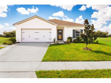 Charming single-story home with a well-manicured lawn and attached two-car garage on a sunny day at 1538 Landon Ln, Haines City, FL 33844