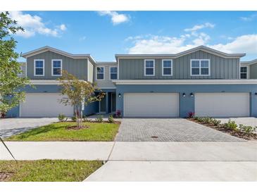 Well-manicured townhomes with two-car garages, manicured landscaping, and paver driveways at 5240 Luisa Ct, St Cloud, FL 34771