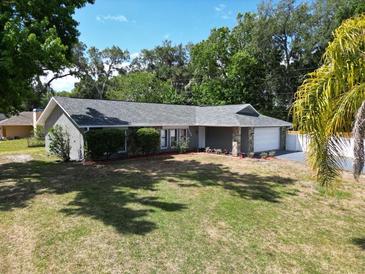 Ranch-style home with stone accents, mature landscaping, and a well-maintained lawn at 2404 Needle Palm Dr, Edgewater, FL 32141