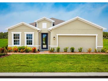 Charming single-story home with a well-manicured lawn and colorful landscaping, complete with an attached two-car garage at 1548 Covey Rise Ter, Winter Haven, FL 33884