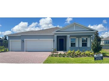 Charming single-story home with a brick driveway, manicured lawn, and a two-car garage at 2193 Aibonito Cir, Clermont, FL 34711