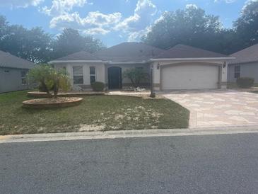 Charming single-story home with a two-car garage, flagstone driveway, landscaped yard and stucco exterior at 1424 Figueroa St, The Villages, FL 32162