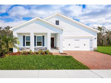 Charming single-story home featuring a brick driveway, a two car garage, and lush green lawn at 1539 Landon Ln, Haines City, FL 33844