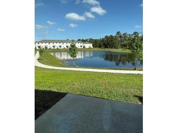 Scenic pond view surrounded by lush greenery and walking path at 7433 Stone Creek Trl, Kissimmee, FL 34747
