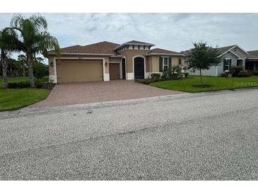 Charming single-story home with a two-car garage, brick driveway, and well-manicured lawn at 803 Jasmine Creek Rd, Kissimmee, FL 34759