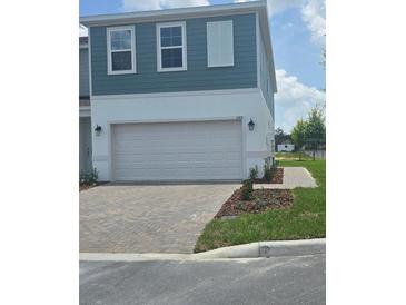 Charming two-story townhouse with a paved driveway and attached two-car garage at 1145 Red Buckeye Ct, Deland, FL 32720